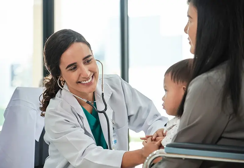 Mom holding son during check-up